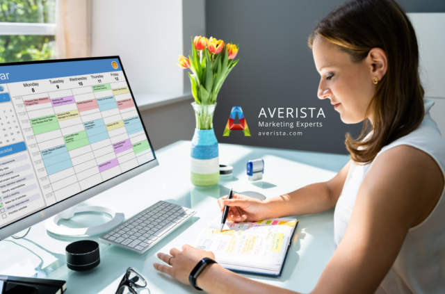 Woman working at a desk with a planning app on her computer, focusing on building a consistent brand.